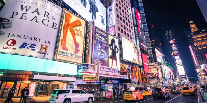 Times Square with billboards featuring various broadway and television programs